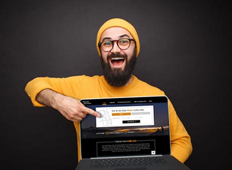 Guy pointing at laptop screen with image of Crypto Enthusiast website